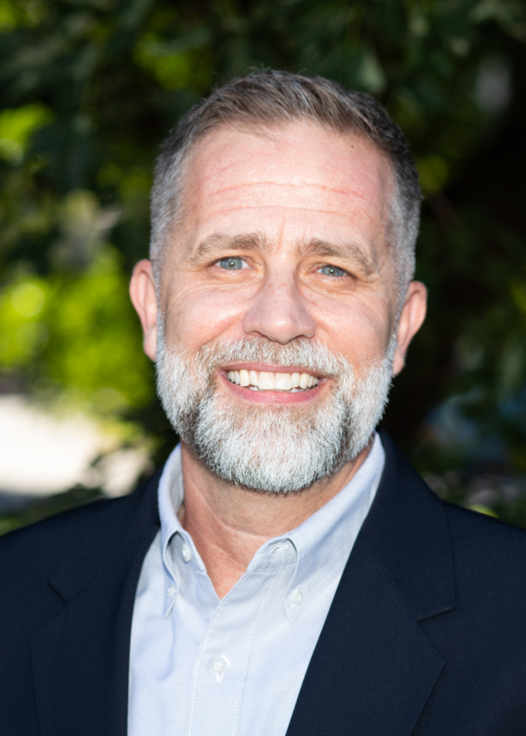 Older White Man, with white beard, collard shirt and suit jacket